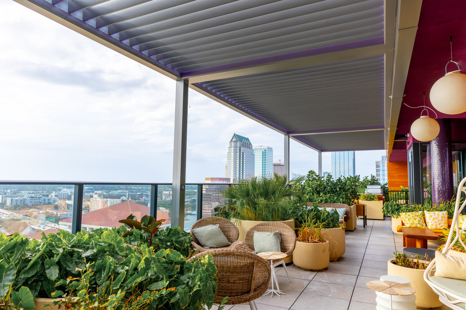 Gray Azenco R-BLADE pergola on a commercial rooftop patio with integrated LED strip lighting &mdash; the assembly type property owners submit to insurance underwriters after hail events.