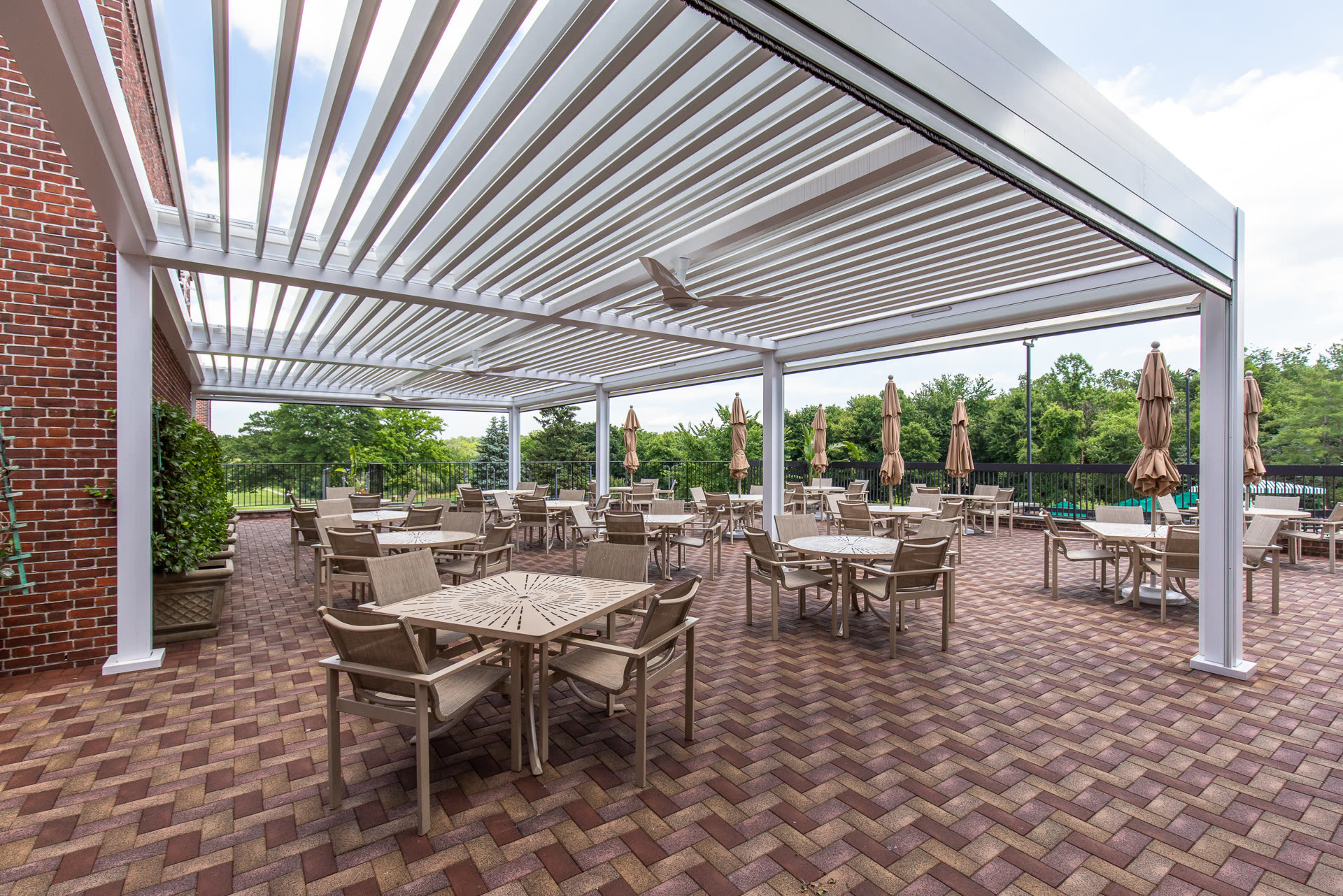 White Azenco R-BLADE louvered pergola over a residential-scale amenity deck &mdash; the format Austin-area HOAs are specifying for clubhouse patios and pool decks.