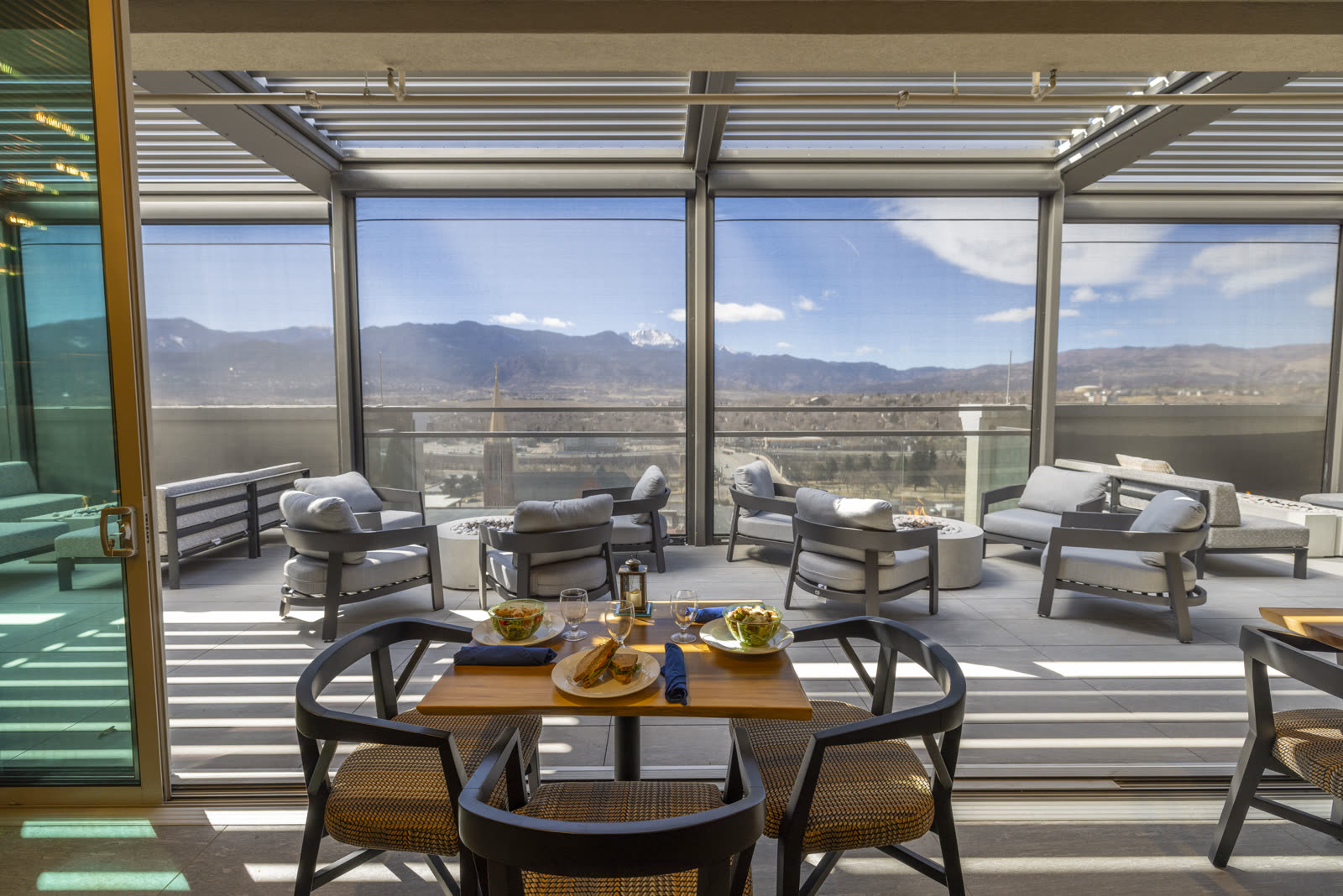 Wide angle of an Azenco commercial pergola installation reading as a corporate amenity plaza &mdash; the design register office park owners use to compete with downtown Class A for tenant retention.