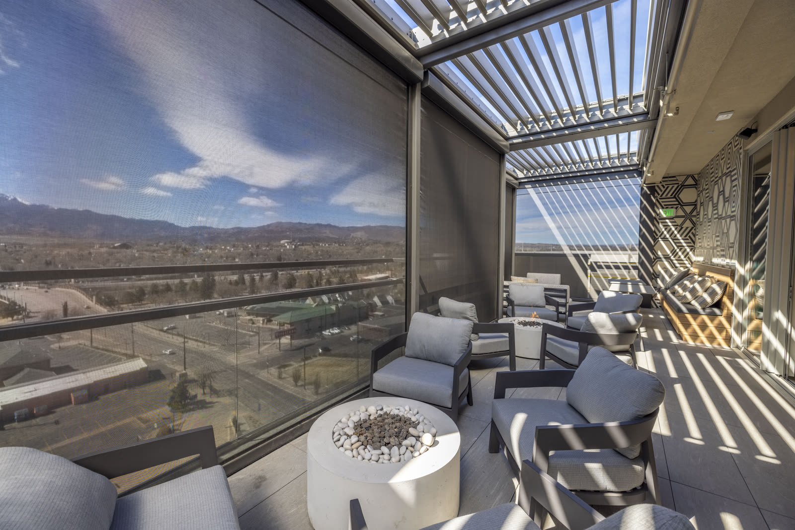 Rooftop terrace with open louvers set beside the building wall and drop screens along the open side. Manufacturer-network installation photo, not a CCSI project.
