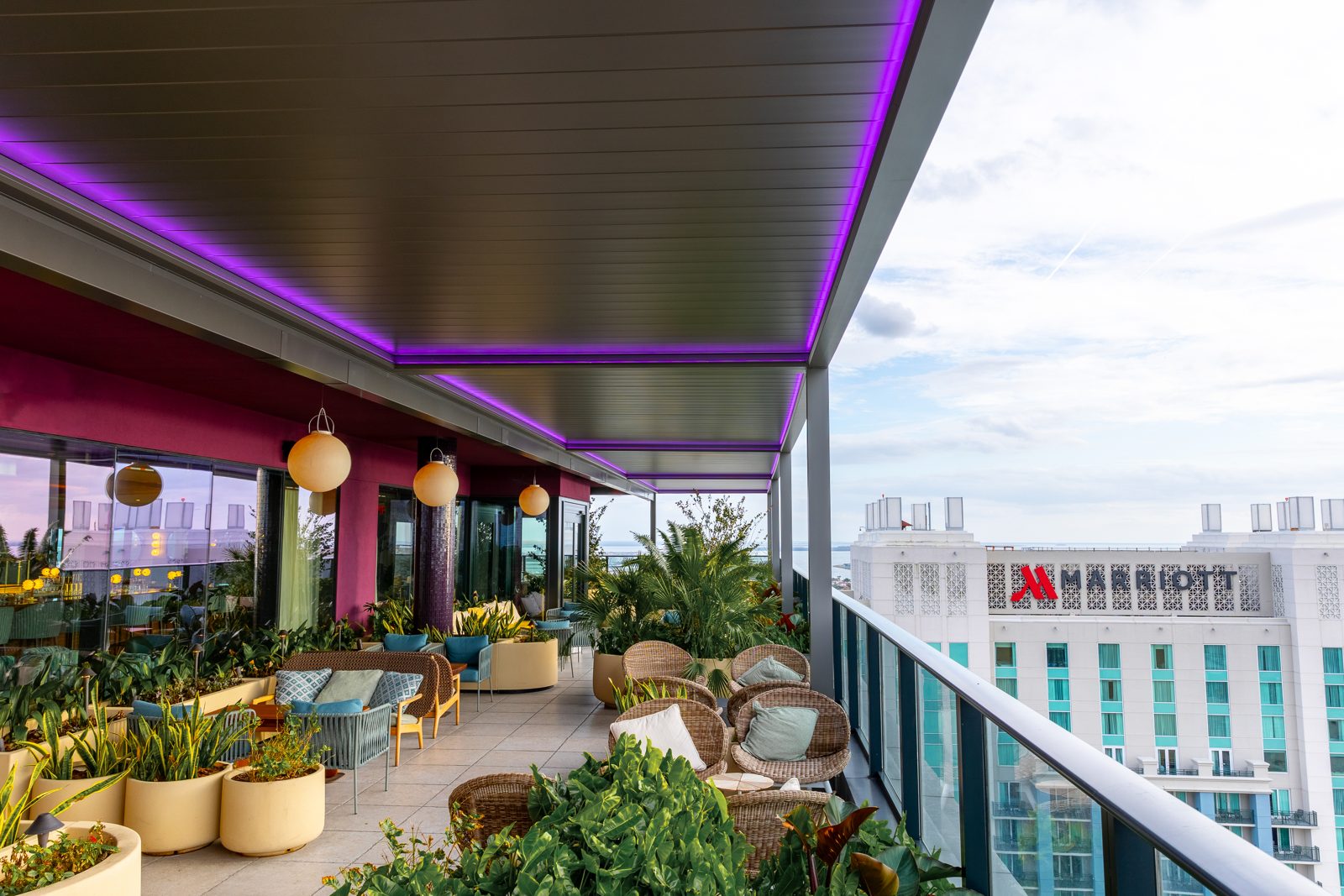 Commercial gray R-BLADE rooftop pergola with RGBW LED strip lighting at night